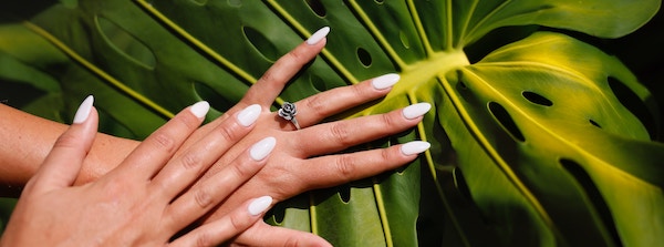 both hands showing nails on a leaf