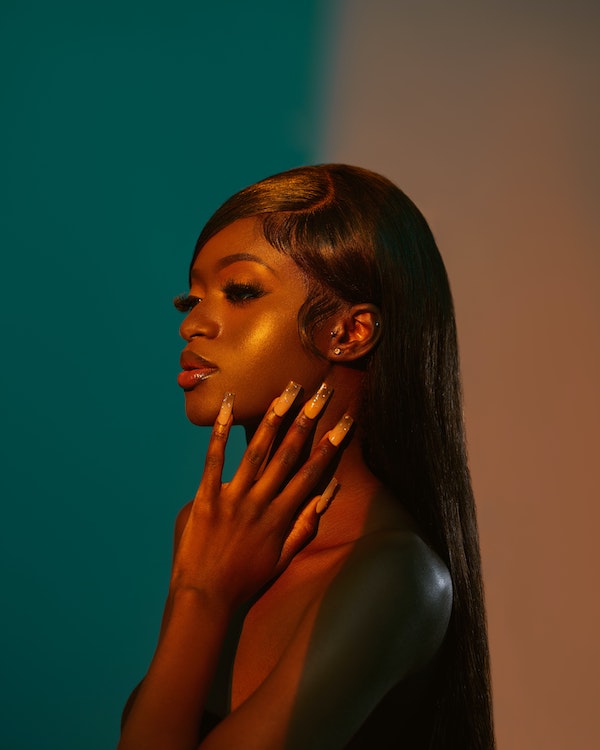 woman showing nails while looking to the side